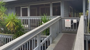 A building with a grey exterior, a white railing, and a sign indicating a stop for trespassers. - Sacino Condo Withlacoochee Rainbow River (Dunnellon)