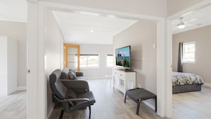 Ein modernes Wohnzimmer mit einer Couch, einem Fernseher und einer Bank.