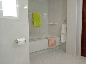 Een bad/douchecombinatie, een haardroger, een bidet, handdoeken
