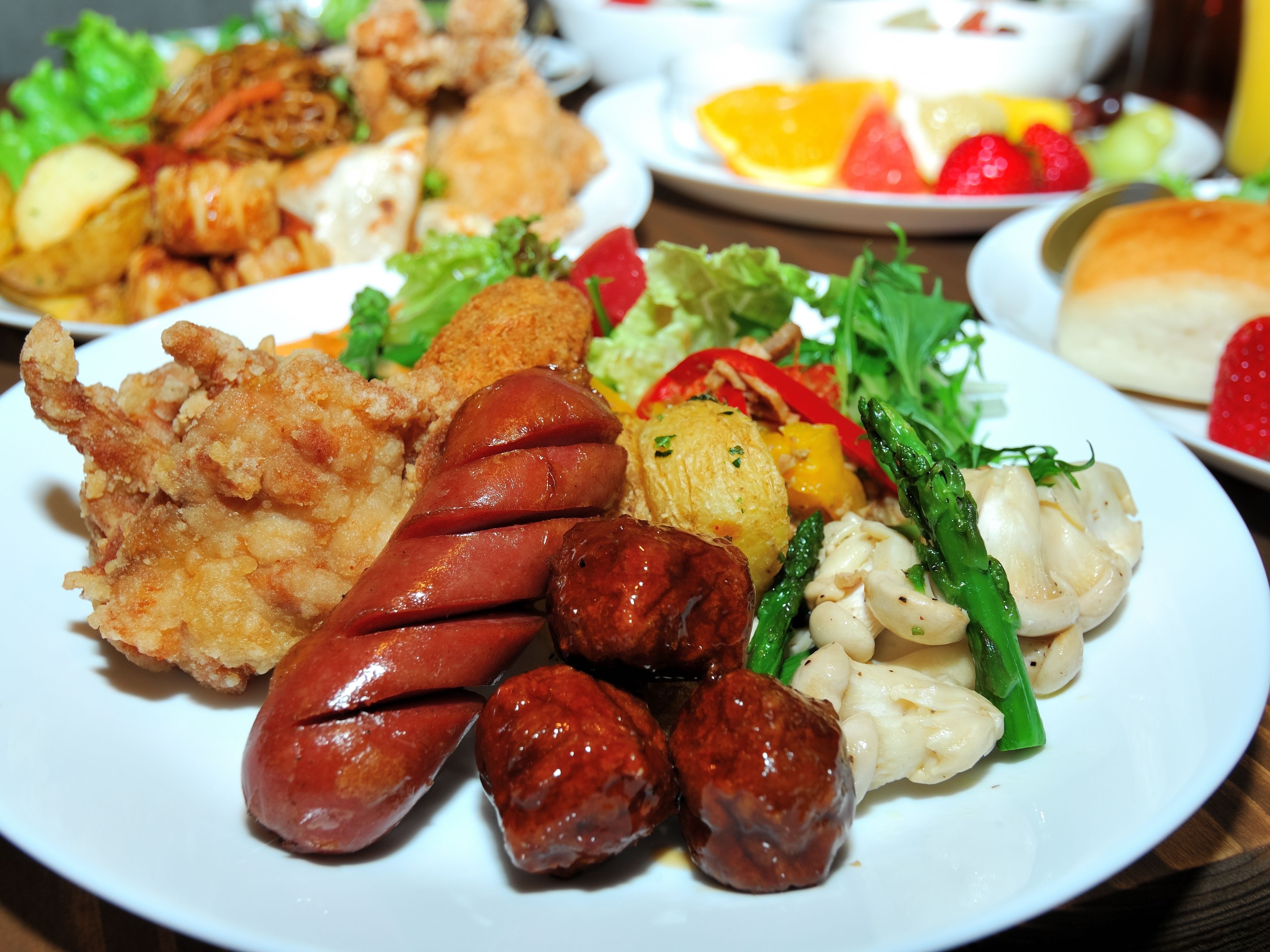 A plate with various foods including sausages, fried items, and vegetables.