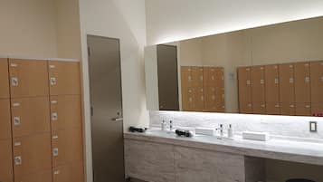 Un baño con taquillas, un lavabo y un espejo.