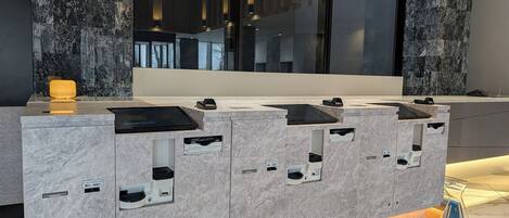 A modern reception desk with built-in charging stations and a digital display.