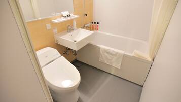 A modern bathroom with a toilet, sink, and bathtub.