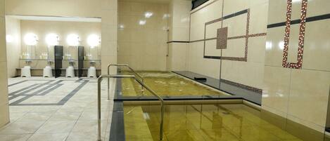 Casa de banho pública com vários lavatórios, espelhos e secadores de mãos.