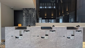 A modern reception desk with built-in coffee machines and a large window with a view of the city.