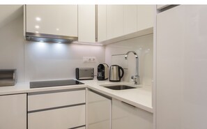 Enjoy cooking in this well-equipped kitchen with a sink, stainless steel range hood, and convenient appliances.