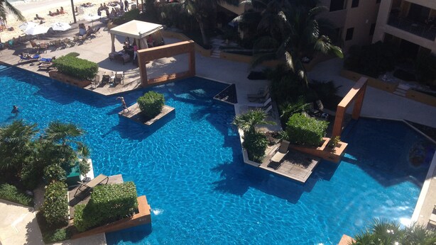 A large, clear blue pool with multiple sections and surrounding lounge areas. - El Faro 303 Surf (Playa del Carmen)
