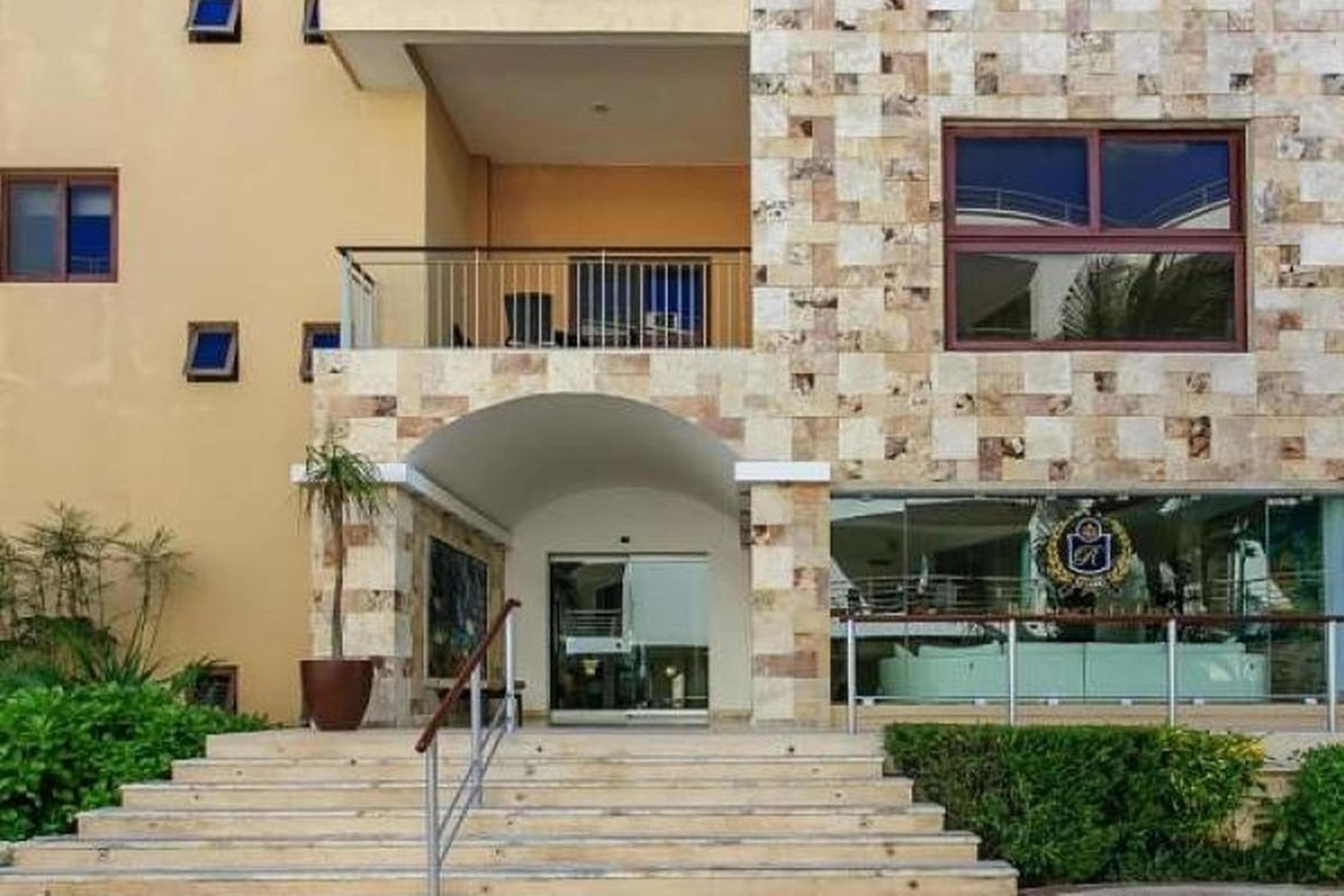 Ein Gebäude mit einer Steinfassade, einem Balkon und einer Treppe, die zum Eingang führt.