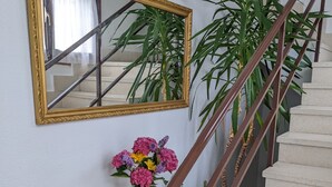A staircase with a wooden handrail and a wall-mounted mirror. - Villa on the coast Santander (Monte - Santander)