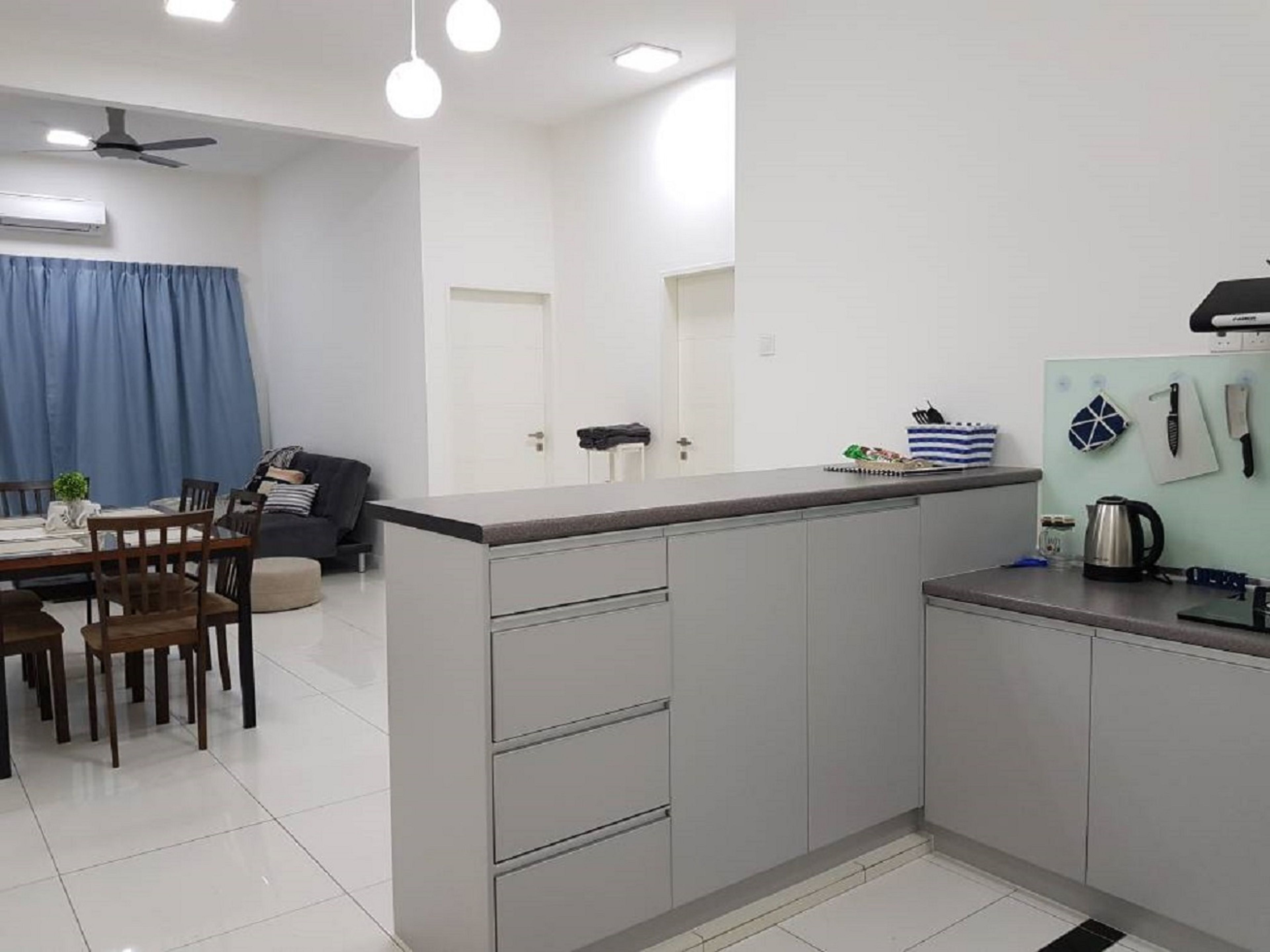 Una cocina moderna con armarios grises, una encimera y un comedor con mesa y sillas.