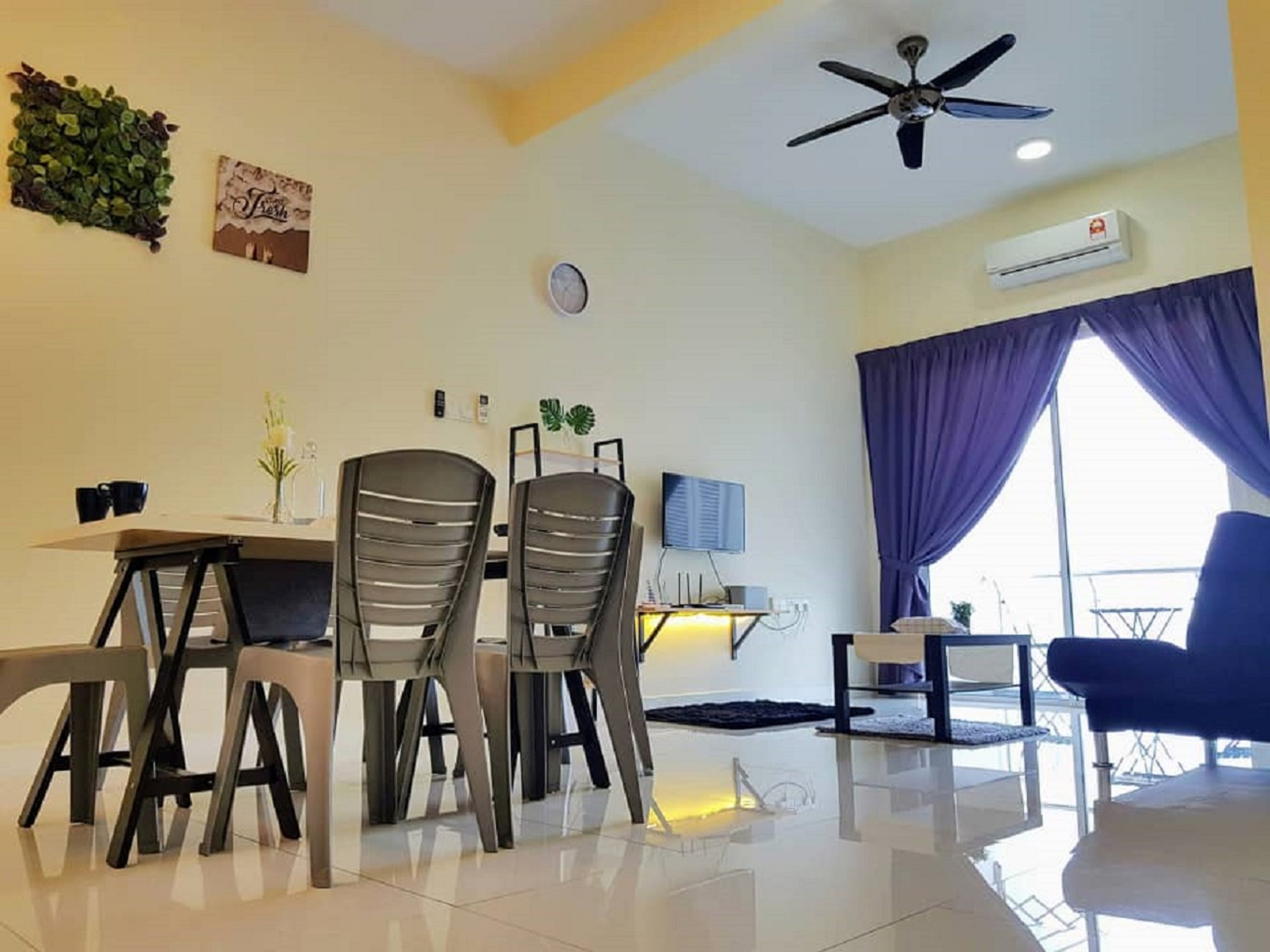 Ett modernt vardagsrum med en matplats, en takfläkt, en luftkonditioneringsanläggning och ett stort fönster med gardiner.