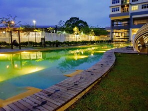 Relax by the serene pool surrounded by lush greenery and modern architecture.