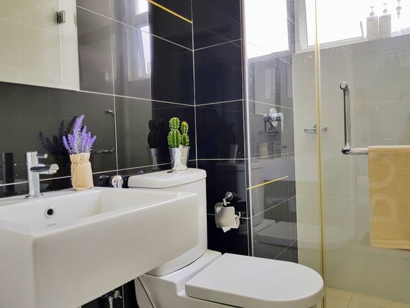 Ein modernes Badezimmer mit Waschbecken, Toilette und Duschkabine aus Glas.