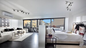 Ein modernes Wohnzimmer mit einer Couch, einem Couchtisch und einem Bett mit Nachtisch.