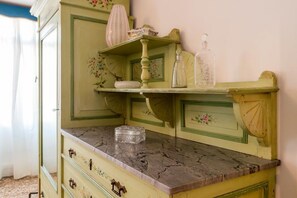 Un aparador de estilo antiguo con tapa de mármol y diseños florales.
