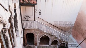 Una scala con ringhiere bianche che conduce a un balcone con tetto in tegole.