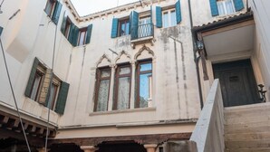 Un edificio con finestre ad arco, un balcone e una scala.