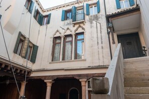 A building with arched windows, a balcony, and a staircase. - Ca' Magno, an enchanting place in Venice (Venezia)
