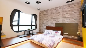 A modern bedroom with a large bed, a brick-patterned wall, and recessed ceiling lights. - Luoyuxuan (Wujie)