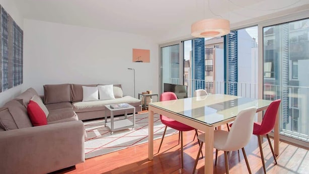 Un salon moderne avec une table à manger en verre, un canapé et une table basse.