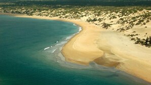 An aerial view of a beach with clear blue waters and sandy shores. - Luxury beachfront holiday house, pool garden all sea views, Forodhani House Lamu (Lamu)