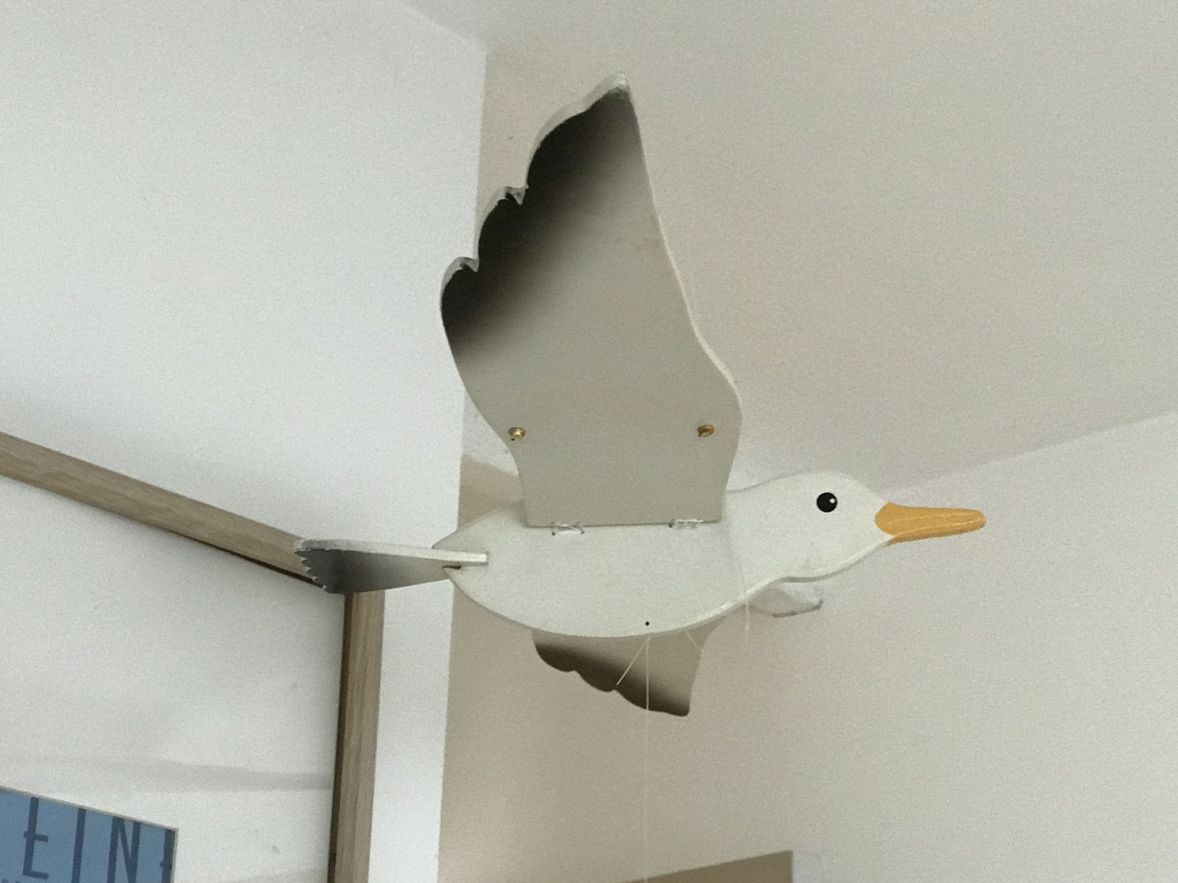 En skulptur föreställande en fågel i flykt, som är upphängd i taket.