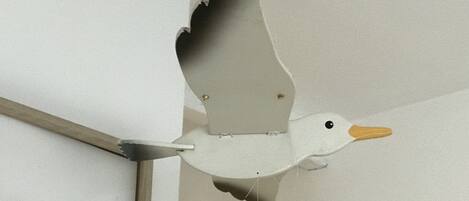 En skulptur föreställande en fågel i flykt, som är upphängd i taket.