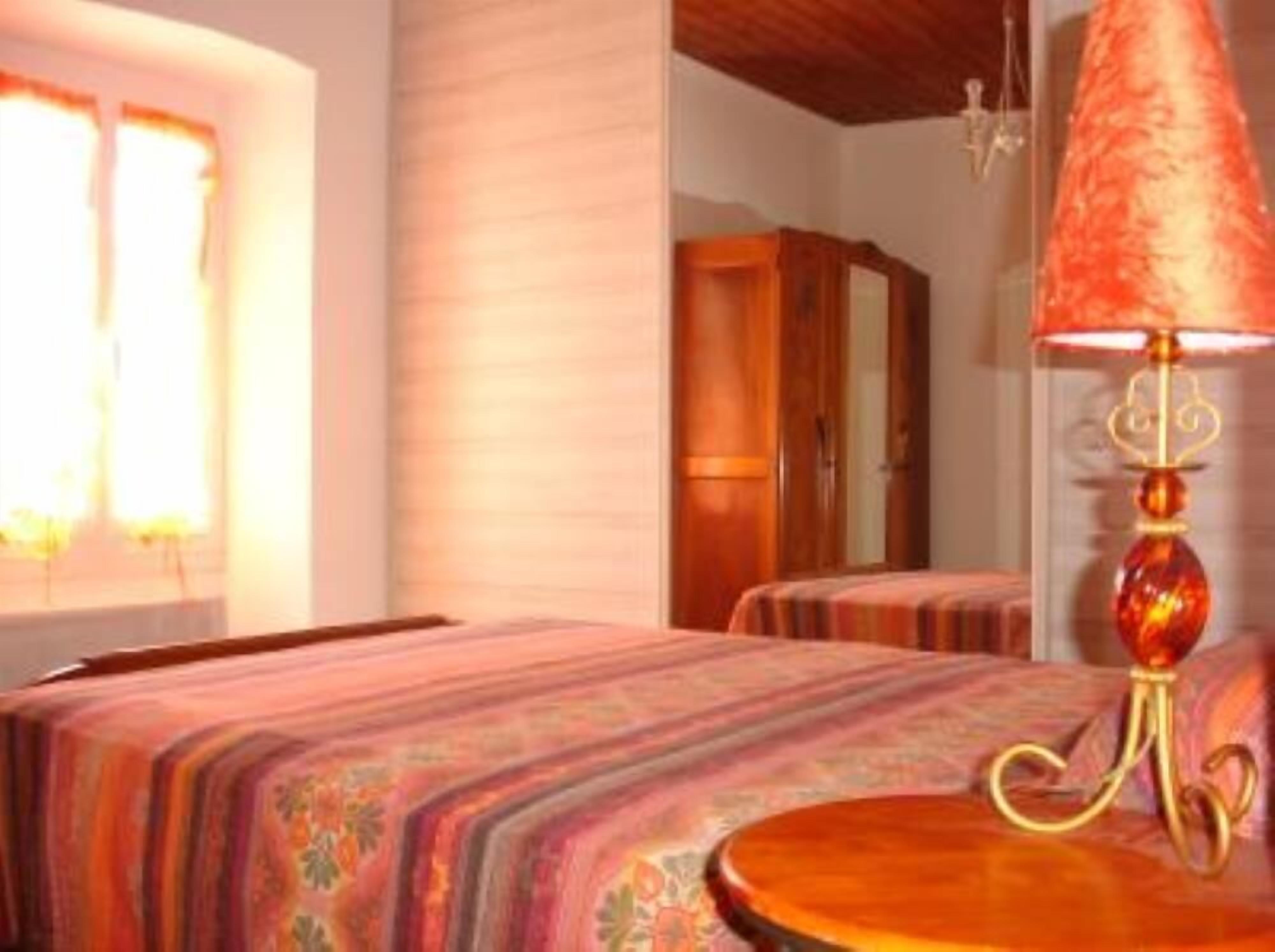 A bedroom with a bed, a bedside table, and a lamp.
