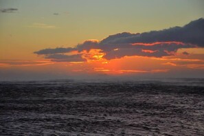 En solnedgång över havet med moln på himlen.