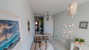 Un soggiorno moderno con un divano, un tavolo da pranzo e una cucina sullo sfondo.