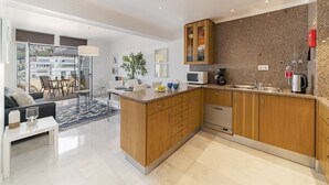 A modern kitchen with wooden cabinets, a built-in microwave, and a stainless steel sink. - Arriaga I, amazing location (Funchal)