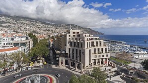 A coastal cityscape with a marina, a prominent modern building, and a roundabout with a fountain. - Arriaga I, amazing location (Funchal)
