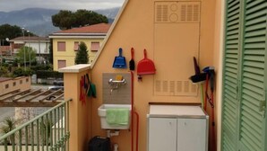A balcony with a tiled floor, a small sink, a cabinet, and cleaning tools. - Apartment/ flat - Marina di Massa (Marina di Massa)