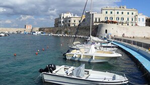 Un port de plaisance avec des bateaux amarrés, un bâtiment doté de nombreuses fenêtres et un ciel dégagé.