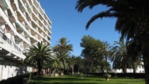 A hotel with a modern architectural design, featuring a patterned facade and surrounded by lush greenery and palm trees. - PENTHOUSE PANORAMIC VIEWS (Montroig)