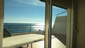 A balcony with a view of the sea, a table, and a chair. - PENTHOUSE PANORAMIC VIEWS (Montroig)