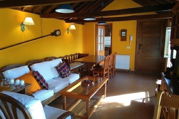 El salón, con la zonas de estar y comedor. Al fondo cocina y puerta de acceso.