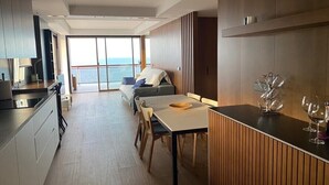 A modern kitchen with a dining area, a sofa, and a view of the sea. - LUXURY APARTMENT APARTMENT 11 with direct views of the sea, sunrises live. (GANDIA PLAYA)