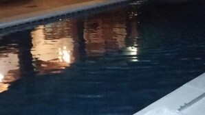 A swimming pool with a clear view of the surrounding area, including a building with steps leading up to a door and a small outdoor seating area. - Holiday home Villa Carmeli (Ardales)