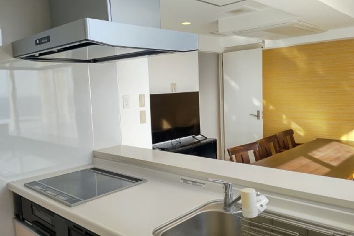 A modern kitchen with a built-in stove, a sink, and a microwave.