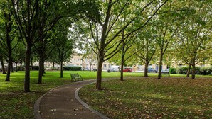 A park pathway with trees and a bench. - Raise the Bar, by Veeve (London)