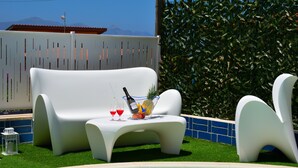 A poolside area with white lounge chairs, a small table with drinks and fruit, and a view of mountains in the background. - Brand new villa with private pool and terrace Alcamo marina (Alcamo)