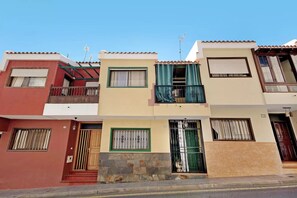 A row of multi-story residential buildings with balconies, windows with curtains, and a clear sky. - Quiet house by the sea / beach, WiFi, child-friendly, terrace - great location (Alcalá)
