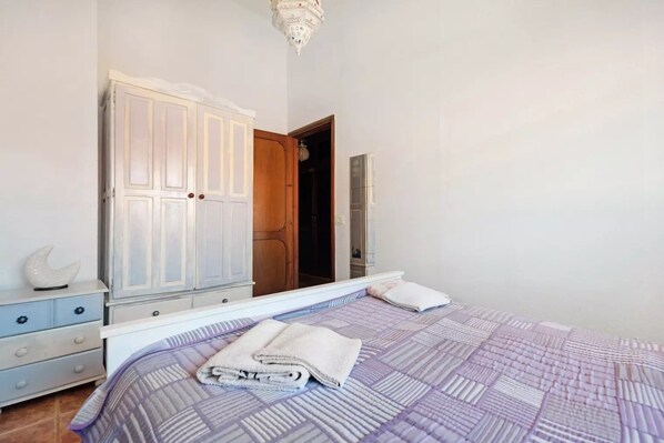 A bedroom with a bed, a wardrobe, a mirror, and a door leading to another room. - Quiet house by the sea / beach, WiFi, child-friendly, terrace - great location (Alcalá)