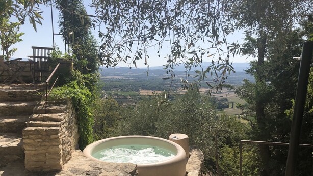 Un sentier de pierres menant à un jacuzzi d’où l’on peut admirer une vallée.