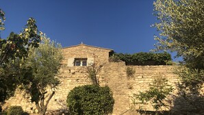 Un bâtiment en pierre avec une petite fenêtre et un mur en pierre.