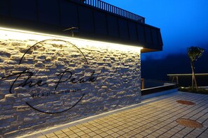 Un muro de piedra con un letrero que dice 'The Peak' y 'die alpine art zu leben'.