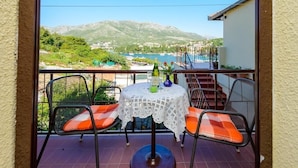 A balcony with a table and chairs, overlooking a scenic view of mountains and a lake. - Room in Cavtat with Seaview, Balcony, Air condition, WIFI (3686-1) (Cavtat)