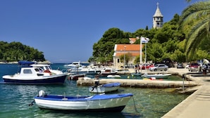 A marina with boats docked, a church with a bell tower, and a clear blue sky. - Room in Cavtat with Seaview, Balcony, Air condition, WIFI (3686-1) (Cavtat)