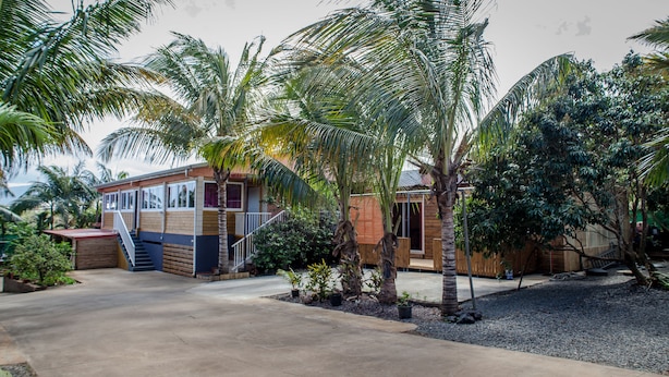A two-story building with a balcony and a covered patio area. - la cariole (Saint-Pierre)